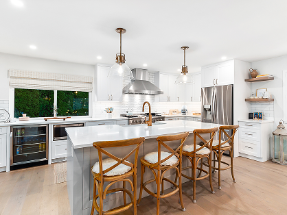 Renovated white kitchen with large island and wood bar stools