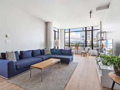 Modern living room with blue sofa and large windows
