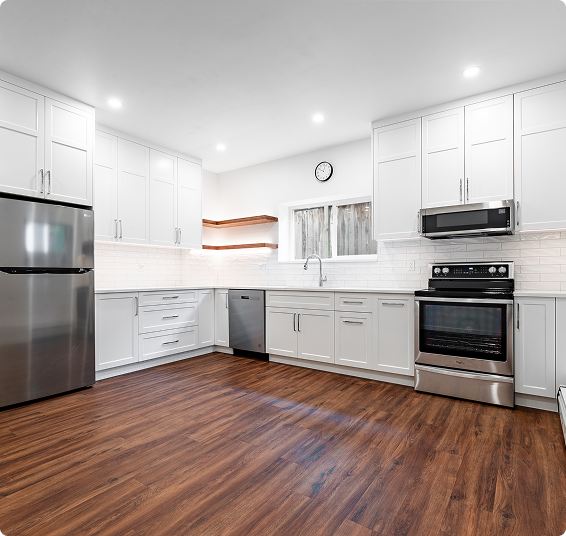 Custom kitchen renovation with white cabinetry and hardwood flooring